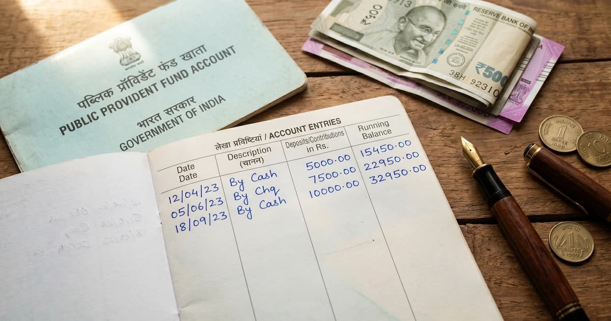 Public Provident Fund passbook with handwritten contribution entries and a coin stack, illustrating how PPF compounds over 15 years